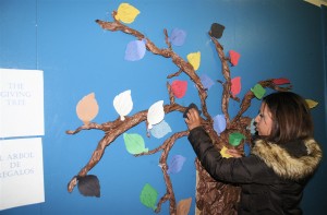 Sasha Barreras, a graduate of the Sunnyside Neighborhood Association’s I AM Youth project, places leaves on the giving tree during a Hermosa Vida meeting held May 12, 2010 in Flagstaff. 