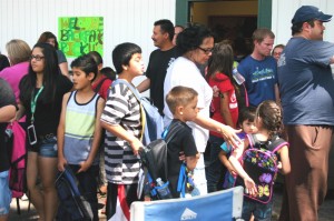 Los niños y sus padres esperan en la cola para recoger material escolar, recibir materiales de educación y salud en la “Feria de Regreso a la Escuela” que se celebró el 19 de julio en el Centro de Alimentos para Familias de Flagstaff. Foto: Frank X. Moraga / AmigosNAZ ©2014  