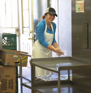 Brooke Potts, a student from Northern Arizona University, cheerfully works at the Flagstaff Family Food Center as part of her 25-hours of community service requirements.